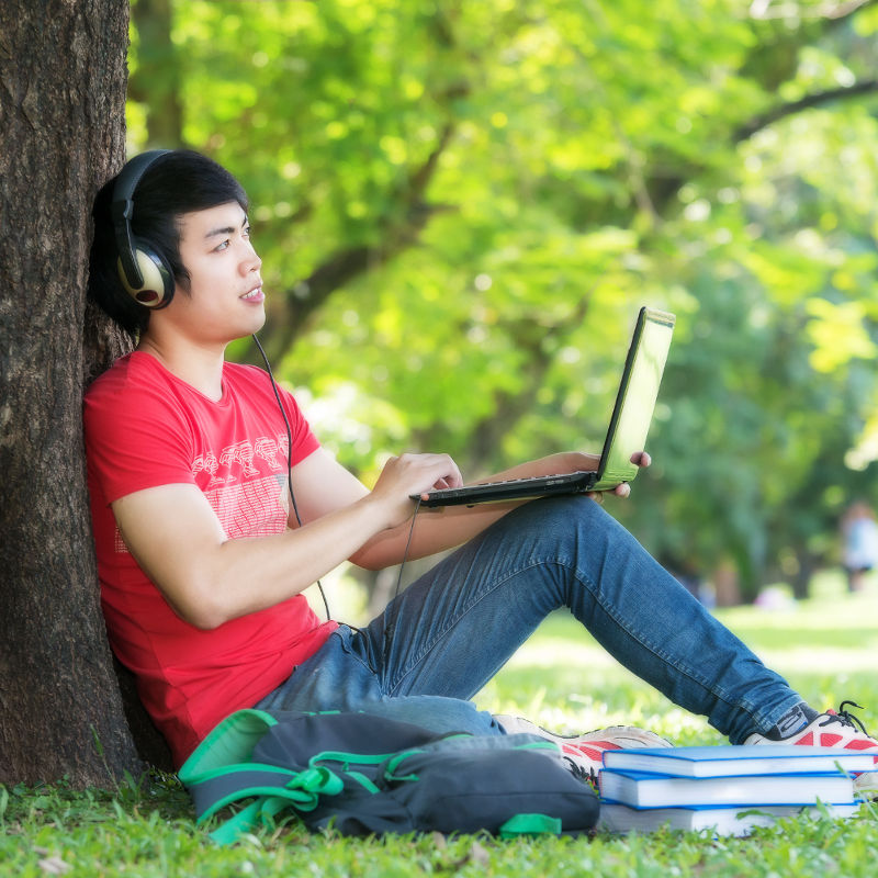 photo of young man with a laptop and headphones