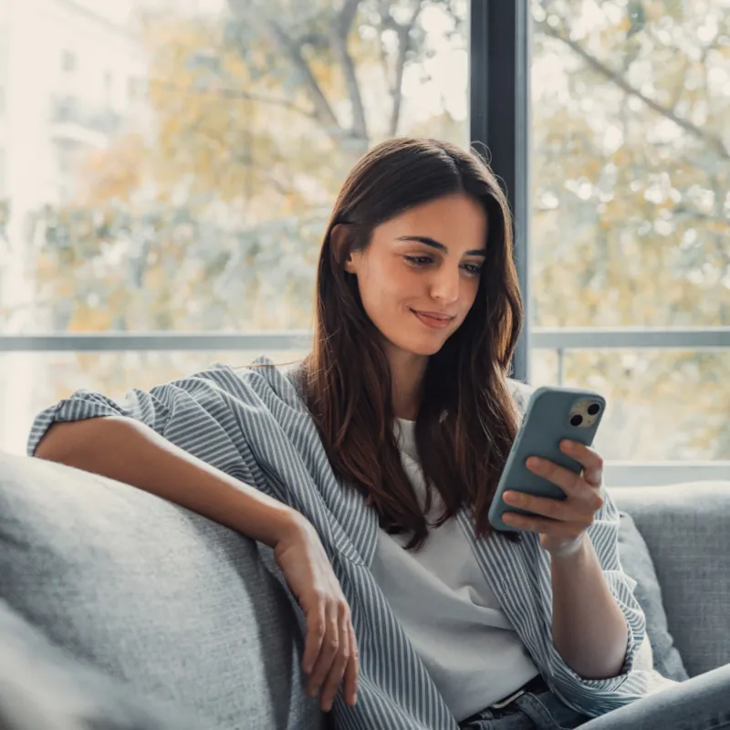 A woman checks her high-yield savings account balance with a mobile device.